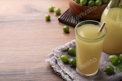 Preview: Tasty gooseberry juice on wooden table. Space for text