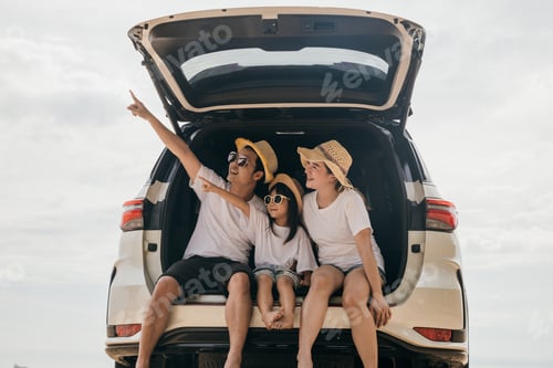 Preview: Father, Mother and daughter enjoying road trip sitting on back car and point finger out blue sky