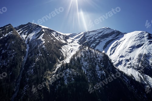 Preview: Beautiful low angle shot of a mountain with snow covering the peak and the sky in the background