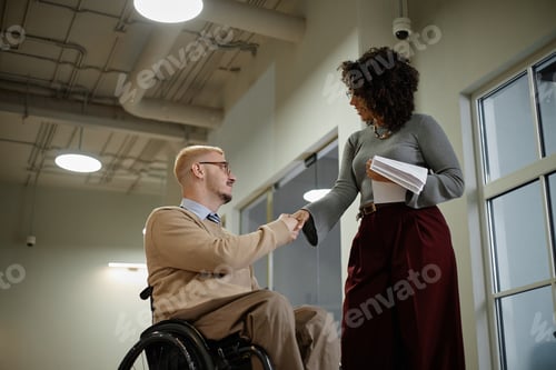 Preview: Caucasian Man with Disability Shaking Hands with Black Woman