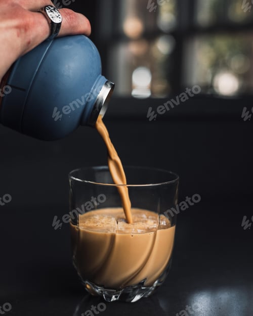 Preview: Closeup of pouring latte coffee into the glass