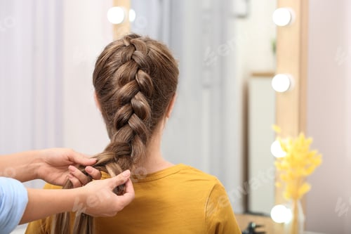 Preview: Professional coiffeuse braiding client's hair in salon