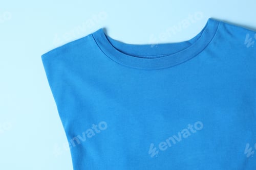 Preview: T-shirt on light blue background, top view. Mockup for design
