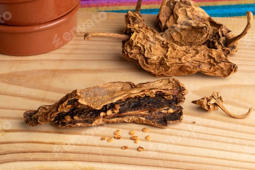 Preview: Whole and halved Mexican Chile Chipotle Meco and seed on wooden background