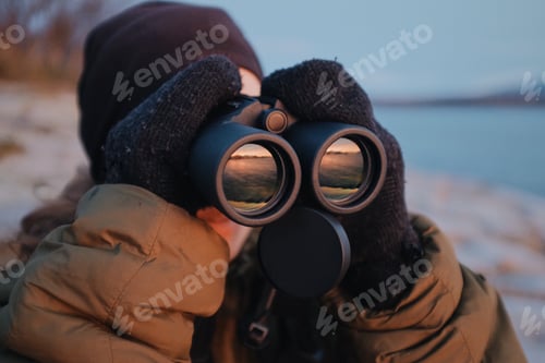 Preview: Caucasian woman using a binoculars outdoors,norway birdwatching