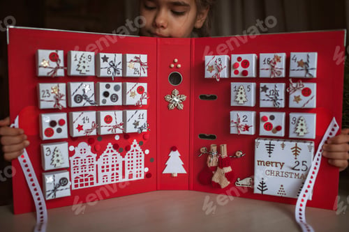 Preview: Pretty girl holds original advent calendar made of jewelry boxes and binder, Christmas diy craft