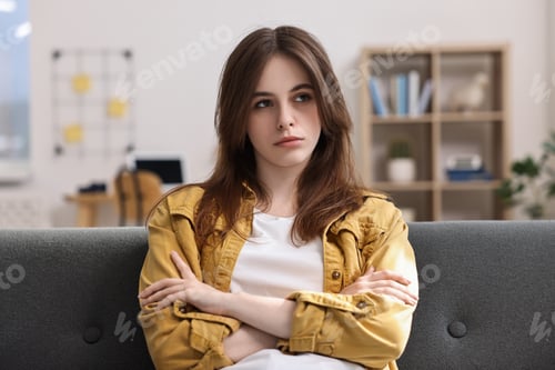 Preview: Loneliness concept. Sad teenage girl on sofa at home