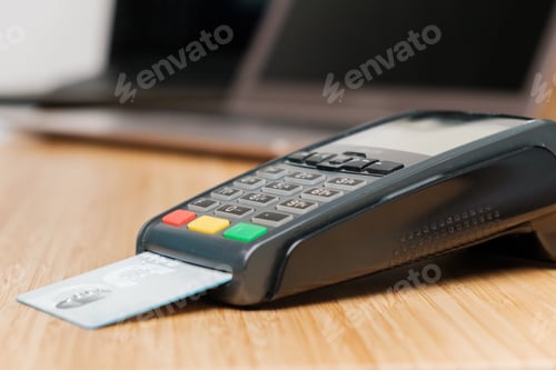 Preview: POS terminal with credit card on the wooden desk