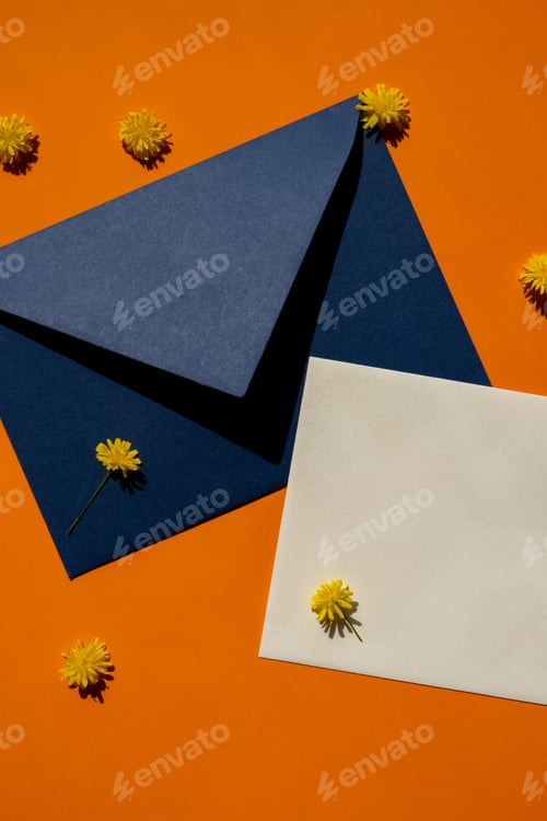 Preview: Beautiful little yellow chamomile daisies flowers on postal blue envelope on orange background