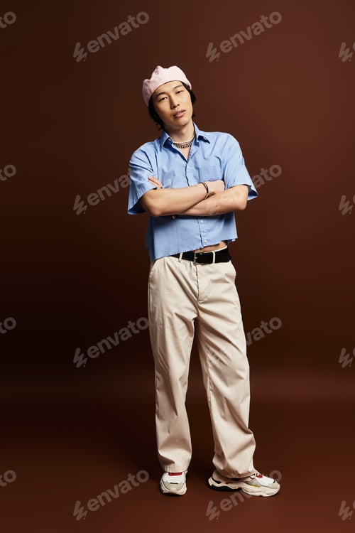 Preview: Stylish young man poses confidently in a modern studio with earthy tones