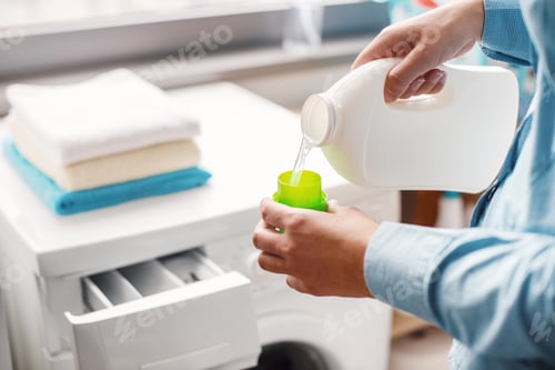Preview: A housewife carefully doses the detergent to put in the washing machine