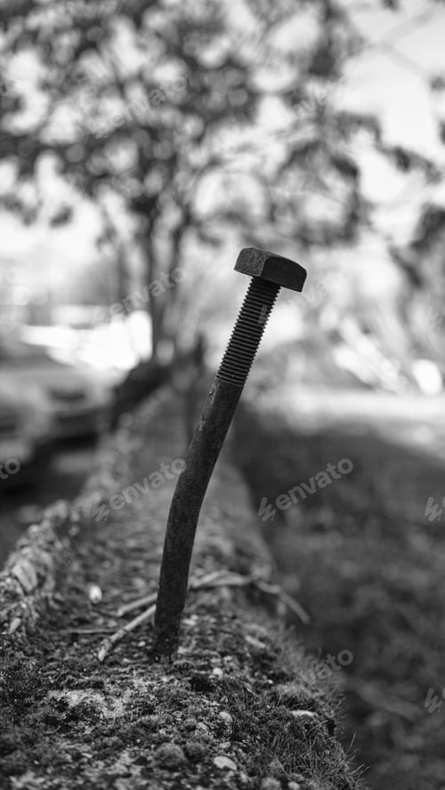 Preview: An old bent rusty screw driven into the wall