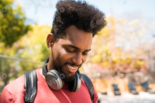 Preview: Young afro man listening to music with headphones.