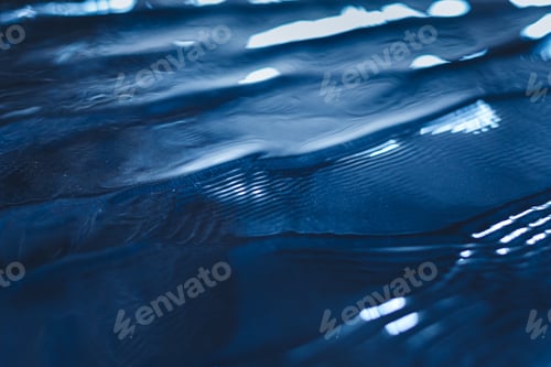 Preview: Closeup of calm water surface texture with waves in dark blue color