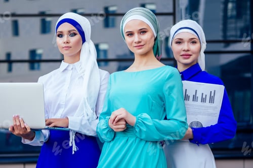 Preview: group of three muslim businesswomen caucasian woman in stylish hijab