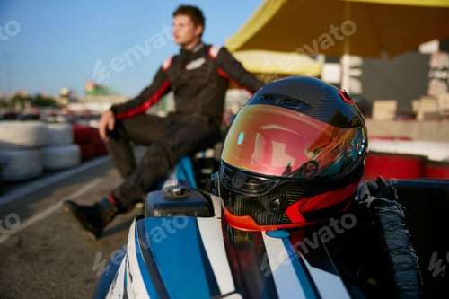 Preview: A racer poses confidently next to a gokart