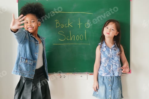 Visualização: Meninas felizes contra o quadro-negro com volta às aulas