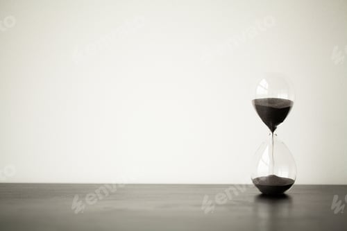 Preview: Time passing. A side view of an hourglass with falling sand