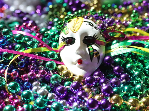 Vista previa: White face mask on colorful beads during the Mardi Gras carnival celebration