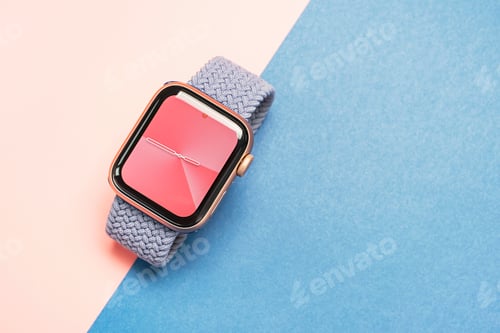 Preview: Seoul - 01.06.2023: Apple Watch with strap on blue and pink background close-up.