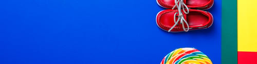 Preview: Banner of Small red boat shoes near big multi-colored lollipop and rope on colored background.