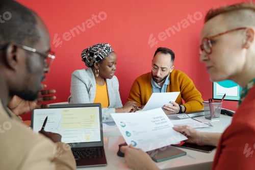 Preview: Colleagues Analyzing Business Papers During Meeting