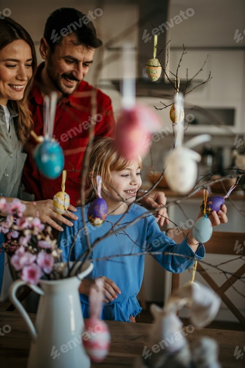 Preview: Child decorating traditional easter tree with colorful eggs
