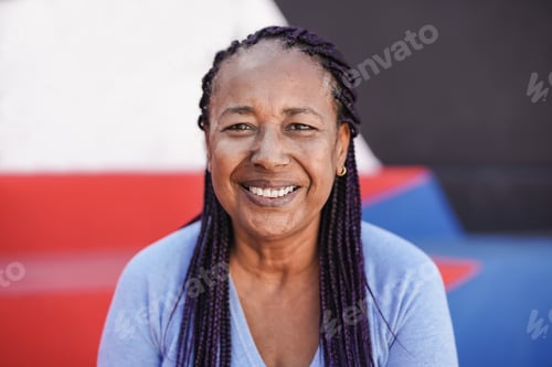 Preview: Happy african senior woman smiling on camera with colorful background