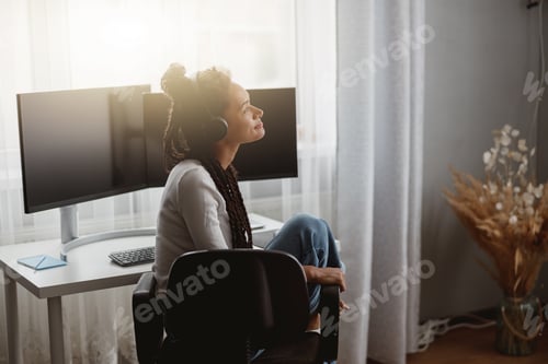Preview: Side view of happy young woman listening to music in black headphones, leisure concept