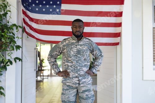 Preview: African american male soldier standing in front of american flag outside home