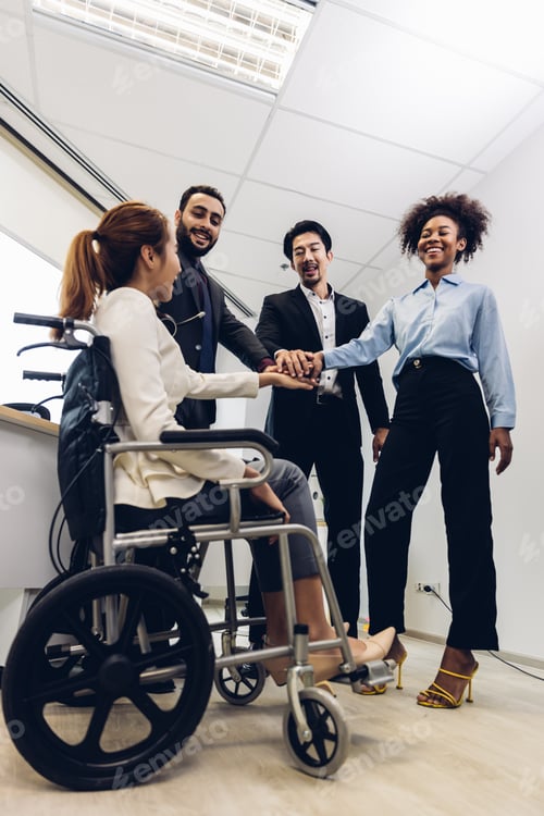 Preview: Office workers and woman on a wheelchair in bright office.