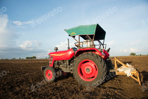 Preview: farmer with tractor preparing land for sowing with cultivator