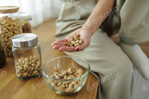 Preview: Healthy Snacking, Young Woman with Nuts in Kitchen"
