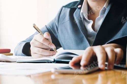 Preview: Businesswoman working on smartphone and writing down notes on notebook. Business planning and