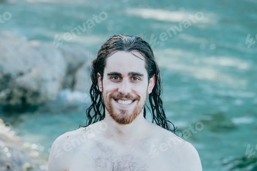 Preview: Man with long hair smiling to camera with wet hair, confidence, holiday concept, portrait, shirtless