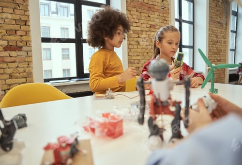 Preview: Logical analysis. Cute little boy and girl making robots during STEM class