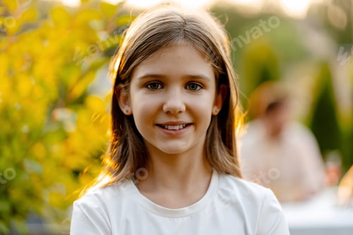 Visualização: Retrato de jovem sorridente curtindo a luz do sol da hora dourada no jardim