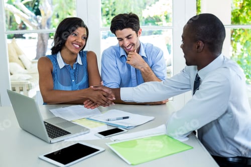 Preview: Happy couple shaking hands with real estate agent