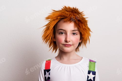 Preview: A small girl with a wig and a clown costume in a studio.
