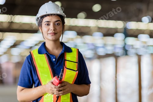 Preview: Portrait Indian woman worker supervisor with engineer safety suit work in large factory warehouse