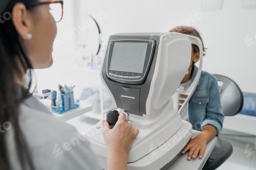 Preview: Female doctor testing little boy for his eyes with special optical apparatus