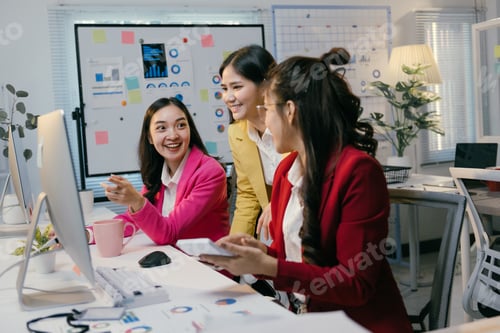 Preview: Three asian businesswomen are working together on a computer, discussing and analyzing financial dat