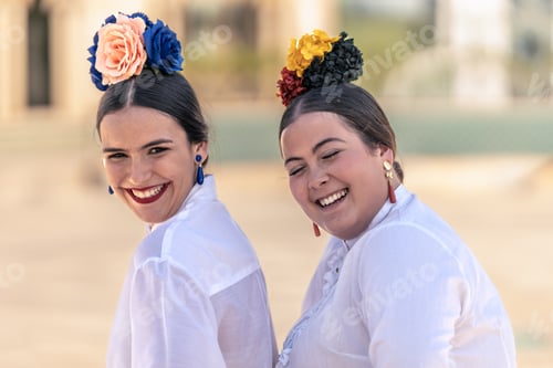 Preview: portrait of two teenage girls in flamenco dresses laughing loudly