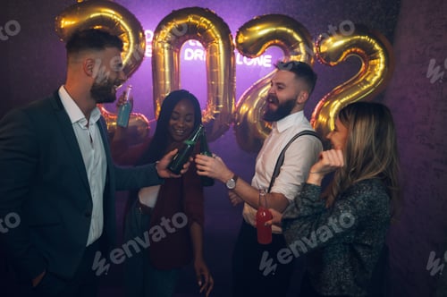 Preview: Happy group of friends celebrate New Year's Eve while dancing in the club