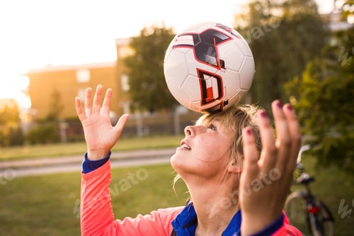 Preview: Sporty woman balancing soccer ball on forehead at park