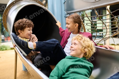 Preview: Joyful autumn playtime with friends in the playground slide