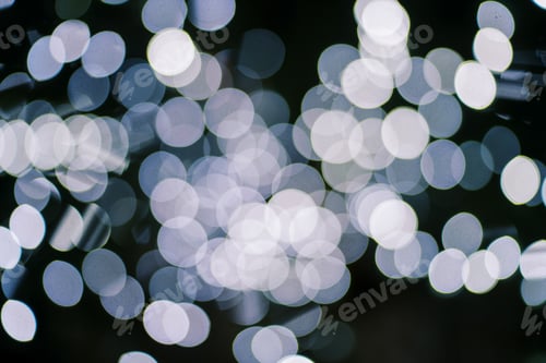 Preview: White sparkling round lights on a dark background. Blur