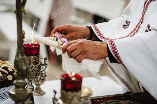 Preview: The priest lights candles before the wedding ceremony. Close up.