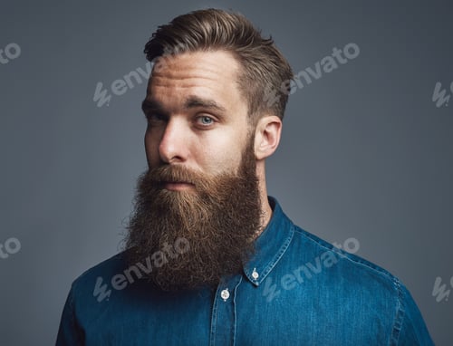 Preview: Bearded young hipster standing alone against a gray background