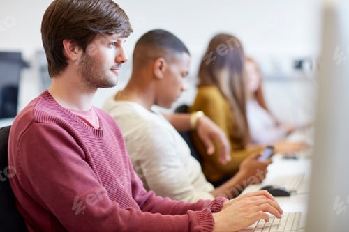 Preview: Students typing on computers in higher education college computer room